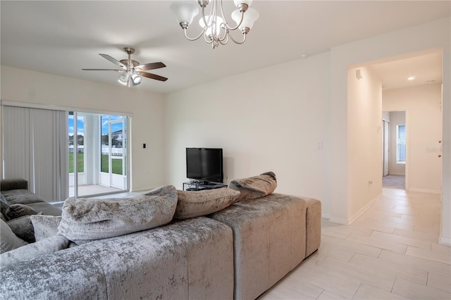 living room featuring ceiling fan with notable chandelier