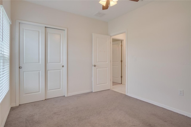 unfurnished bedroom with light colored carpet, a closet, and ceiling fan