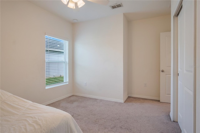 carpeted bedroom featuring a closet and ceiling fan