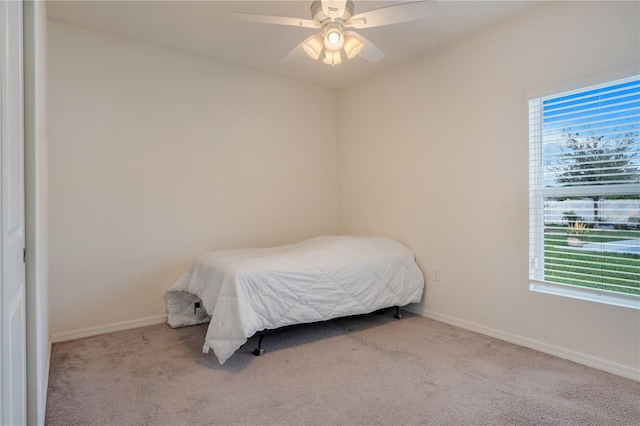 carpeted bedroom with multiple windows and ceiling fan