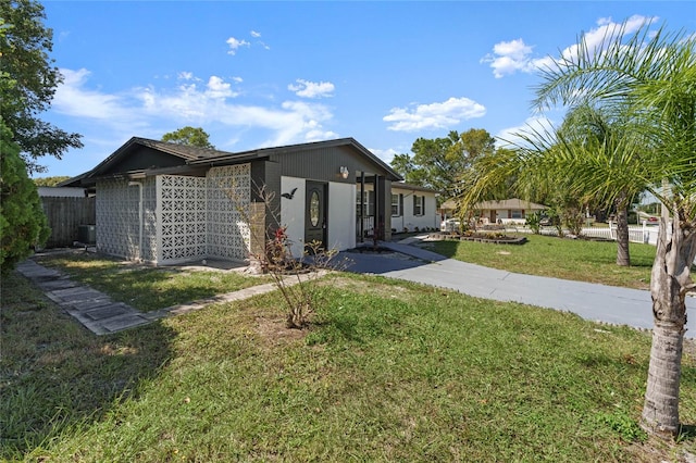 view of front of home with central air condition unit and a front yard