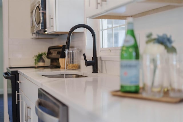 details featuring appliances with stainless steel finishes and white cabinetry