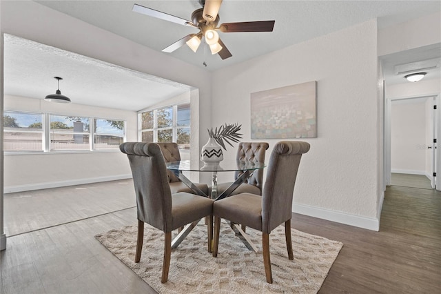 dining area with a textured ceiling, wood-type flooring, and ceiling fan