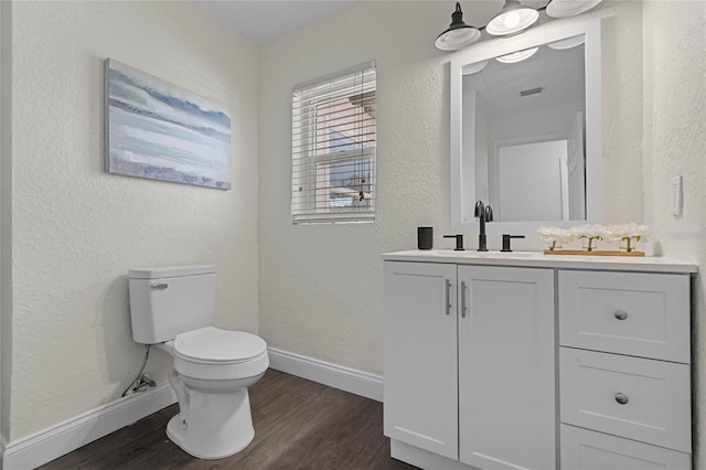 bathroom featuring vanity, hardwood / wood-style flooring, and toilet