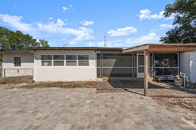 back of property featuring a sunroom and a patio area