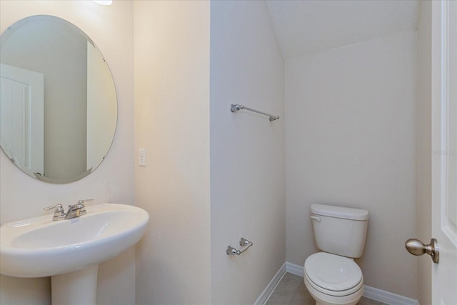 bathroom with sink, toilet, and tile patterned flooring