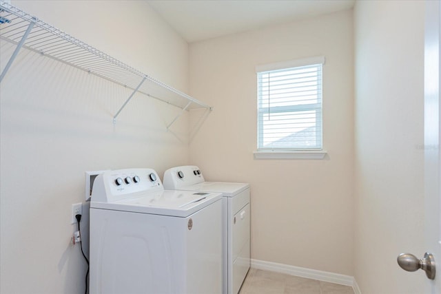 clothes washing area featuring washer and clothes dryer and light tile patterned floors