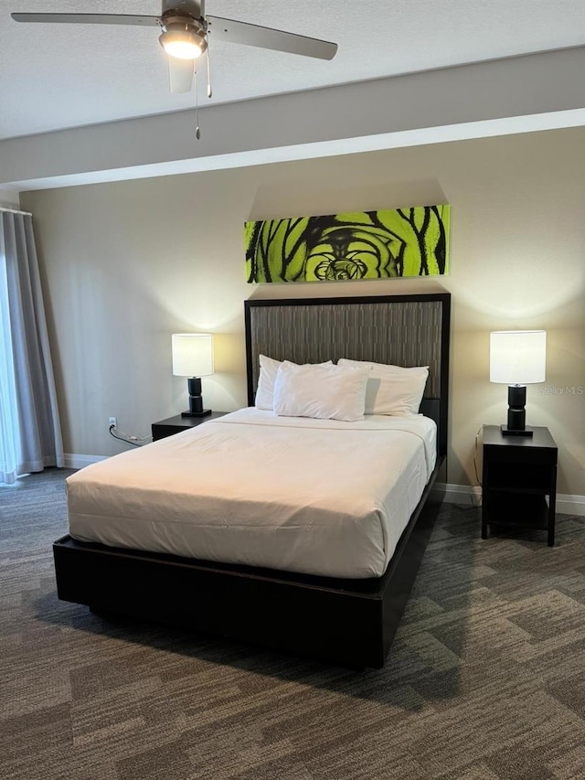 bedroom with ceiling fan and dark carpet