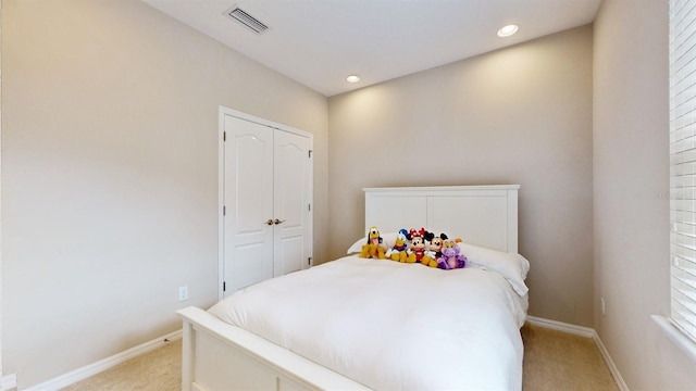 bedroom with a closet and light carpet