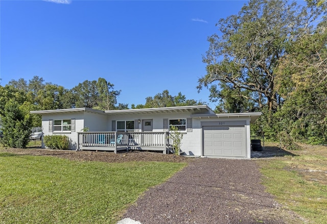 view of front of house with a garage, a front yard, and a wooden deck