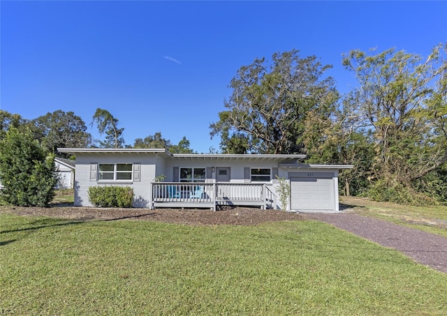 single story home with a garage, a front yard, and a deck