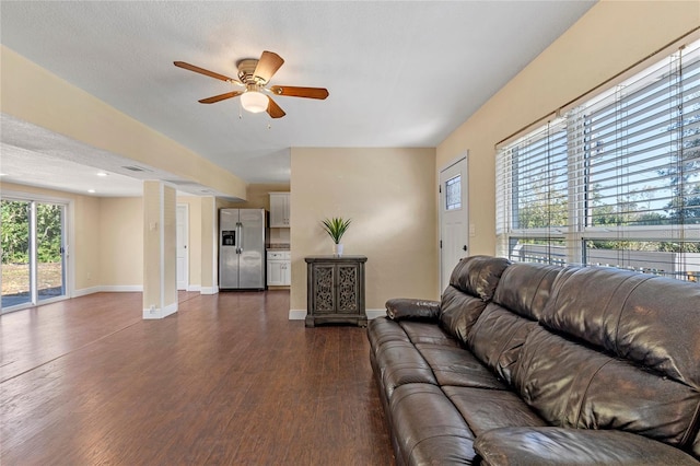 living room featuring ceiling fan, dark hardwood / wood-style floors, and a textured ceiling