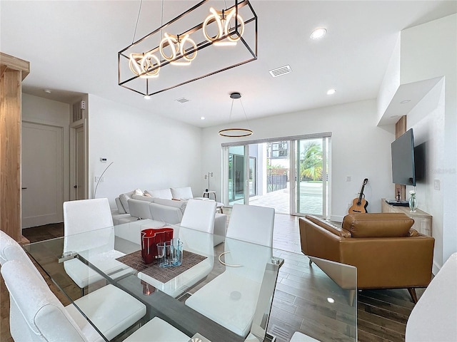 dining area with dark hardwood / wood-style flooring and a chandelier