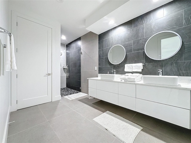 bathroom featuring vanity, tiled shower, tile walls, and tile patterned flooring