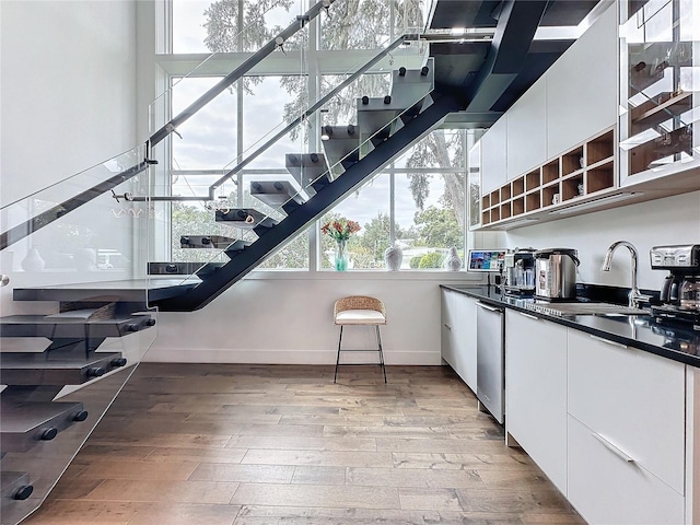 stairway with hardwood / wood-style floors and sink