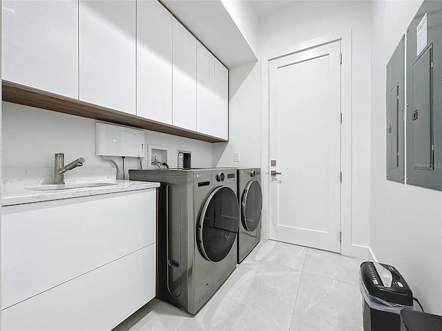 clothes washing area with sink, cabinets, and washing machine and clothes dryer