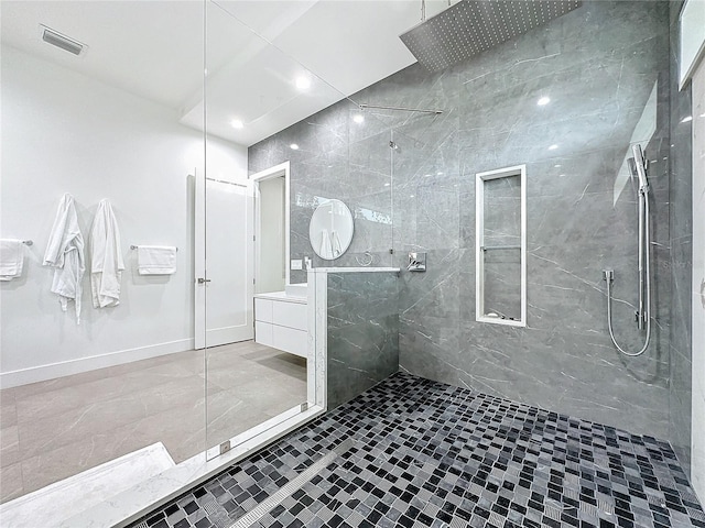 bathroom with vanity, tiled shower, and tile patterned floors