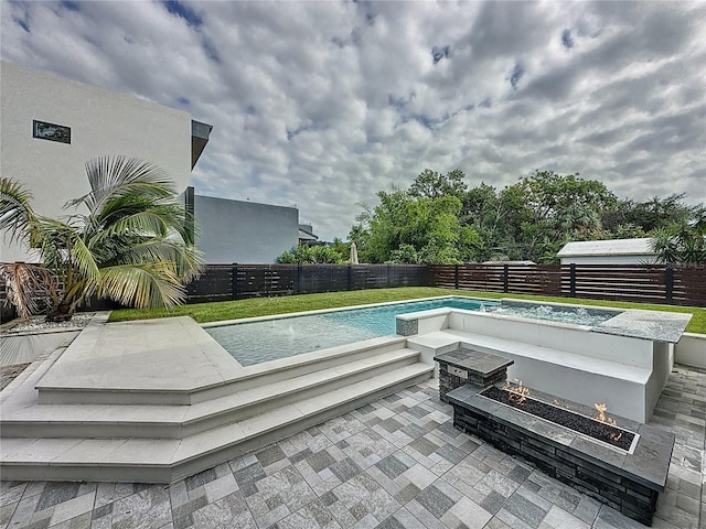 view of pool featuring a patio area and a fire pit