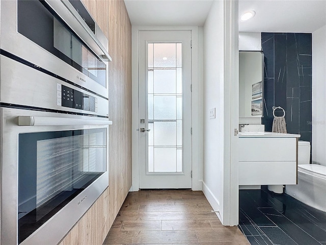 doorway to outside featuring tile walls and dark hardwood / wood-style flooring