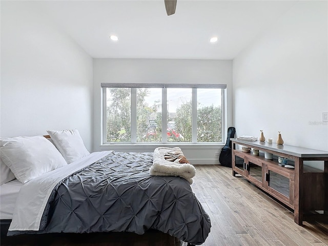 bedroom with light hardwood / wood-style floors, multiple windows, and ceiling fan