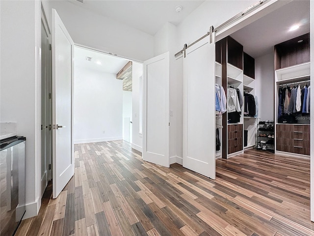 interior space with dark wood-type flooring and a barn door