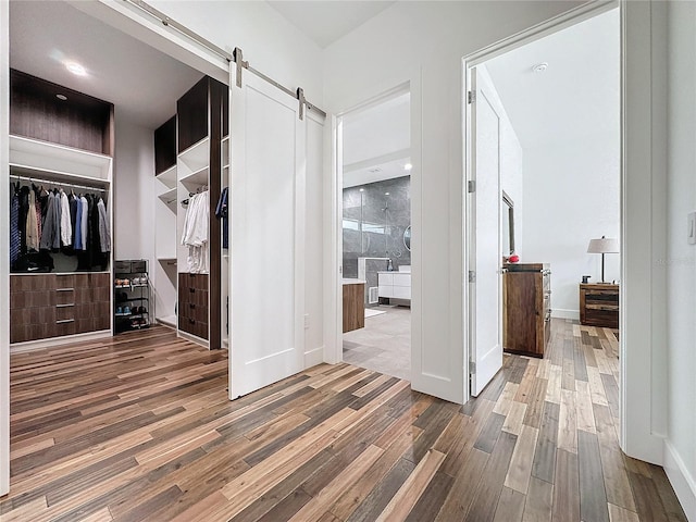 corridor with a barn door and dark hardwood / wood-style floors