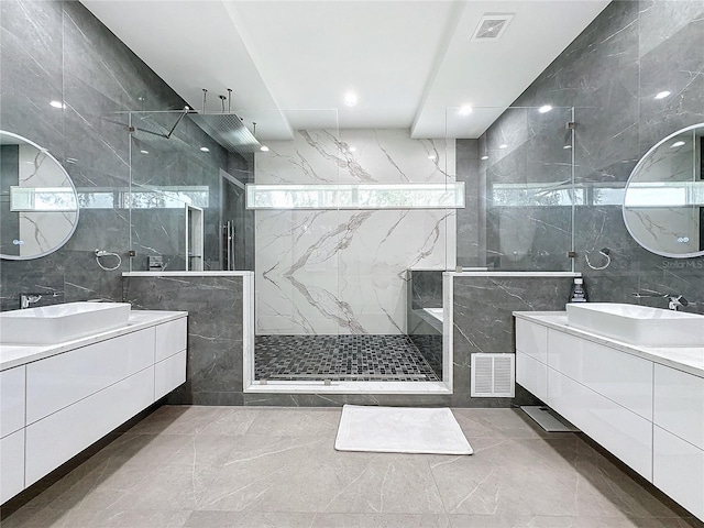 bathroom with vanity, tile walls, and tiled shower