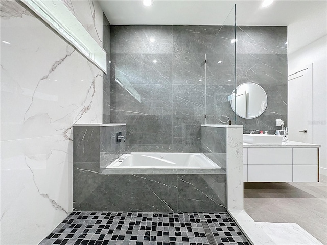 bathroom with tile walls, vanity, and independent shower and bath