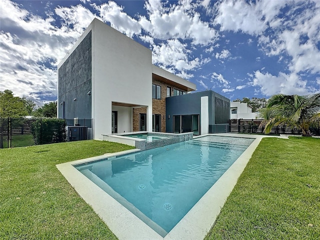 back of house with a swimming pool with hot tub, central AC, a yard, and a patio