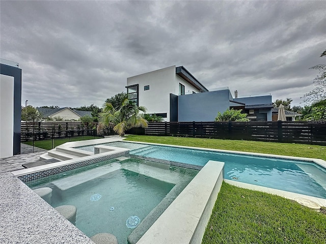 view of swimming pool featuring an in ground hot tub and a lawn