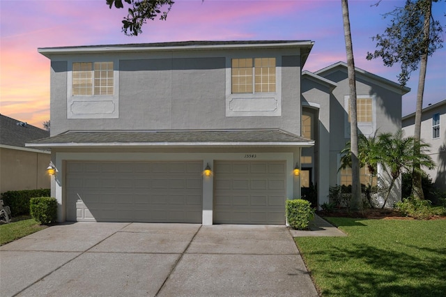 view of property featuring a lawn and a garage