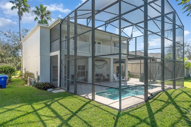 rear view of house featuring a patio, a lanai, a balcony, a fenced in pool, and a lawn