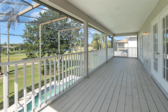 deck featuring glass enclosure and a lawn