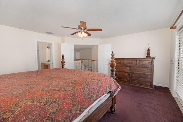 carpeted bedroom featuring ceiling fan, a textured ceiling, and ensuite bath