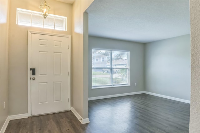 foyer entrance featuring a textured ceiling and dark hardwood / wood-style flooring