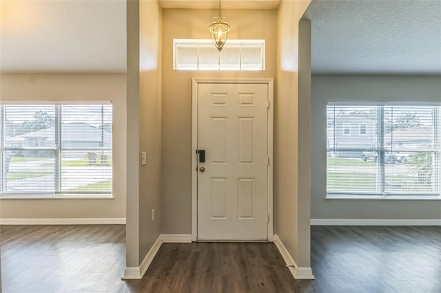 entrance foyer featuring a textured ceiling and dark wood-type flooring