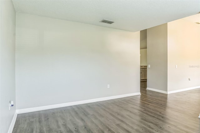 unfurnished room with hardwood / wood-style floors and a textured ceiling