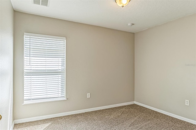 carpeted spare room with a textured ceiling