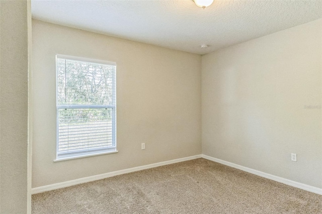 carpeted spare room with a textured ceiling