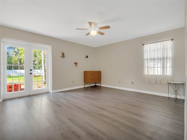 empty room featuring french doors, hardwood / wood-style flooring, and ceiling fan