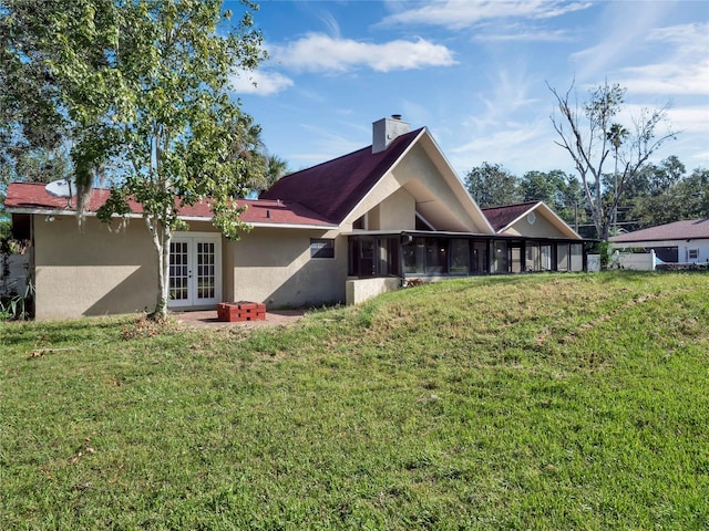 rear view of house featuring french doors and a yard