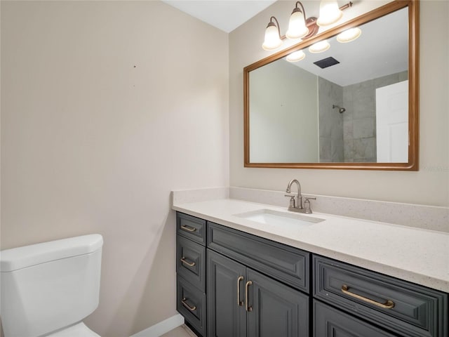 bathroom featuring vanity, a tile shower, and toilet