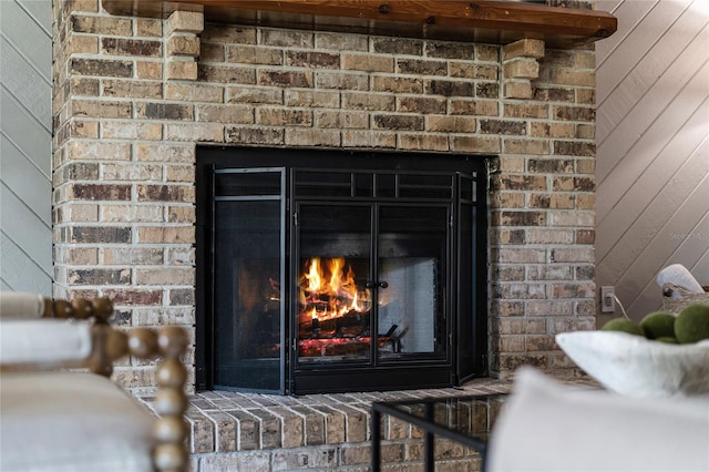 room details with wooden walls and a brick fireplace