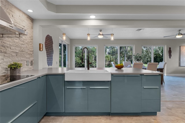 kitchen with black electric stovetop, a healthy amount of sunlight, wall chimney exhaust hood, and kitchen peninsula