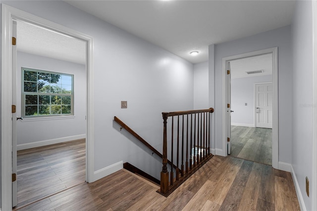 stairway with hardwood / wood-style flooring and a textured ceiling