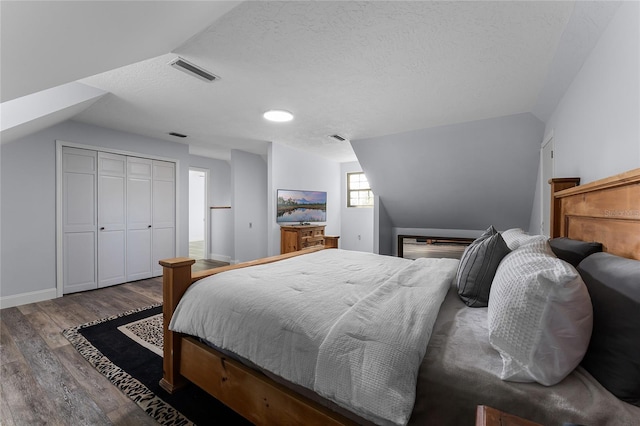 bedroom featuring a closet, hardwood / wood-style flooring, and vaulted ceiling