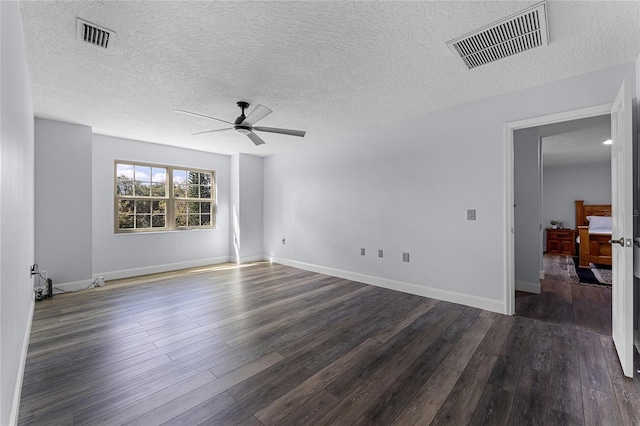 spare room with dark wood-type flooring, a textured ceiling, and ceiling fan