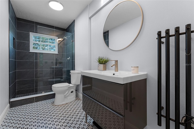 bathroom featuring vanity, toilet, and a tile shower