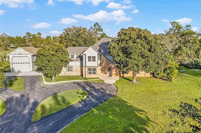 english style home with a front yard and a garage