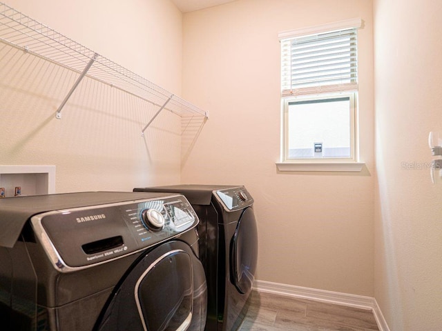 laundry room with light hardwood / wood-style flooring and separate washer and dryer